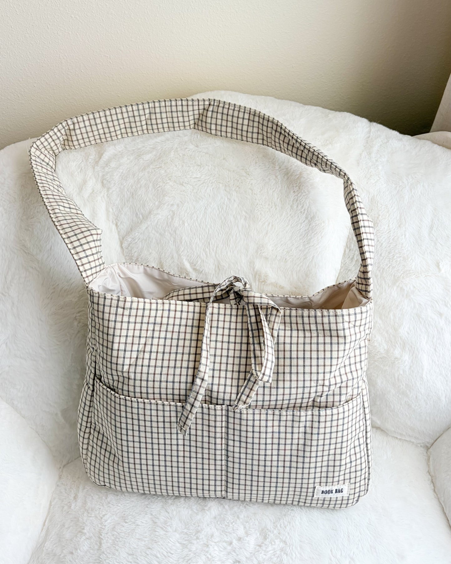 Checkered bag on a white surface with a neutral background