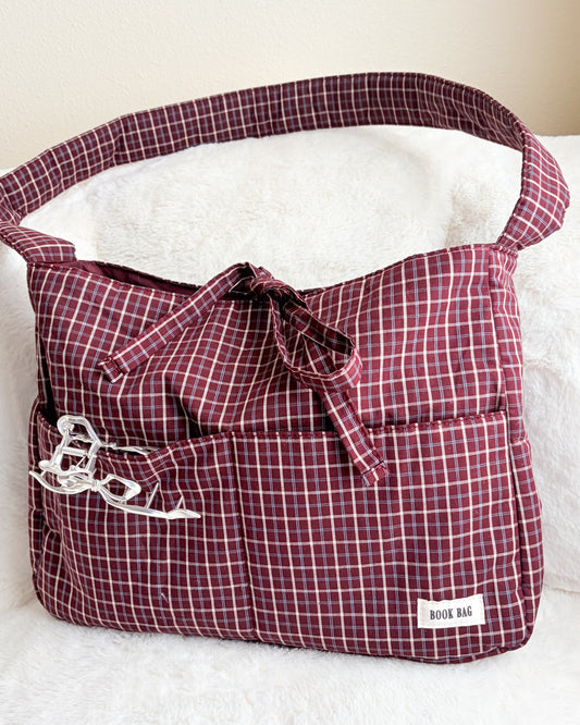 Plaid bag with a bow on a white surface