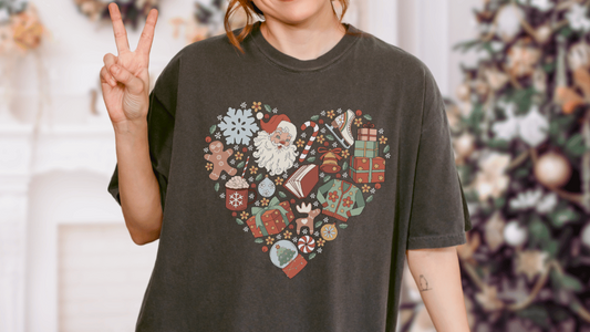Black t-shirt with heart-shaped Christmas print featuring Santa, books, gifts, and festive icons.