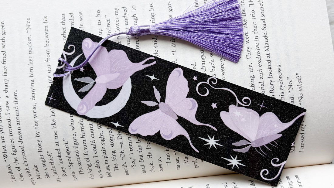 Purple butterfly bookmark with tassel on open book, perfect for book lovers and readers.