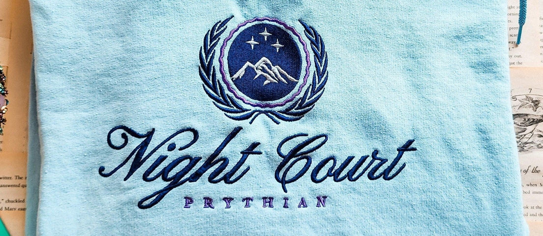 Light blue fabric with 'Night Court Prythian' embroidery and starry mountain crest, inspired by ACOTAR.