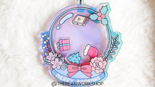 Holographic ornament with Christmas book, gift, tree, and floral accents on soft fabric