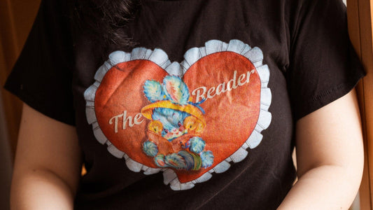 Black t-shirt with heart graphic, text 'The Reader,' and a cute reading bunny illustration.
