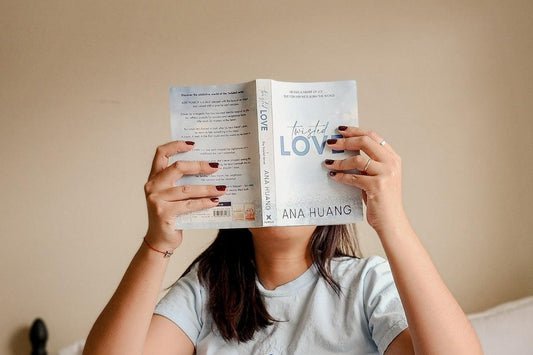 Woman reading "Twisted Love" by Ana Huang, book-focused cozy literature scene indoors
