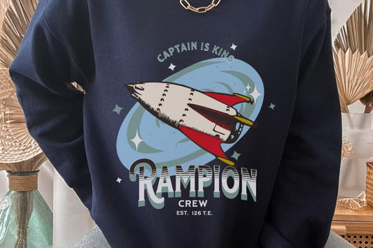 Navy sweatshirt with retro rocket ship, 'Captain is King' and 'Rampion Crew' graphic print.