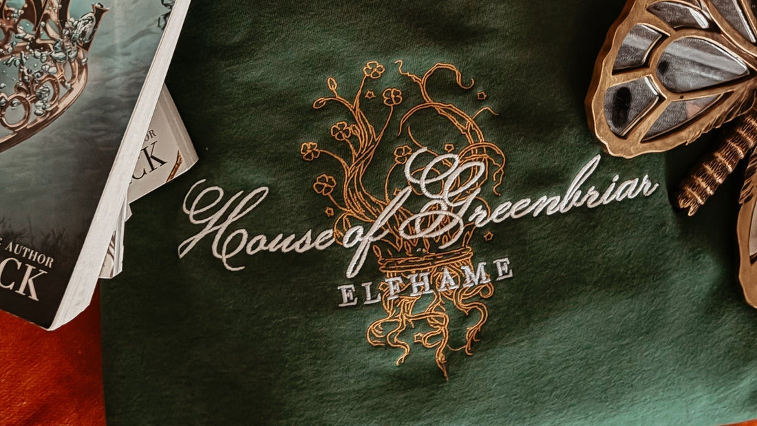 Green sweatshirt with House of Greenbriar Elfhame embroidered, surrounded by fantasy books.