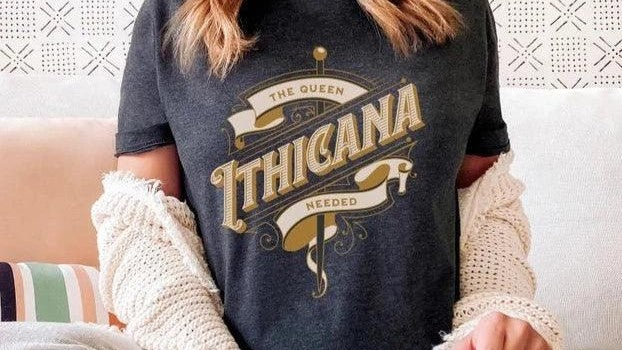 Woman wearing black t-shirt with 'The Queen Ithicana Needed' fantasy book quote design