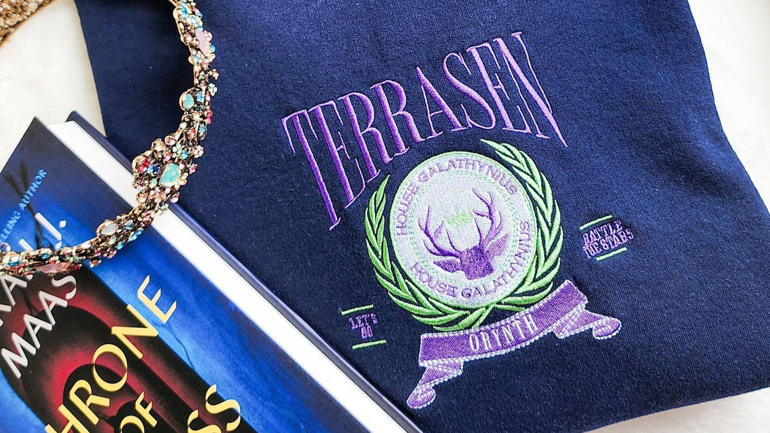 Throne of Glass book, ornate necklace, and Terrasen House Galathynius embroidered pouch