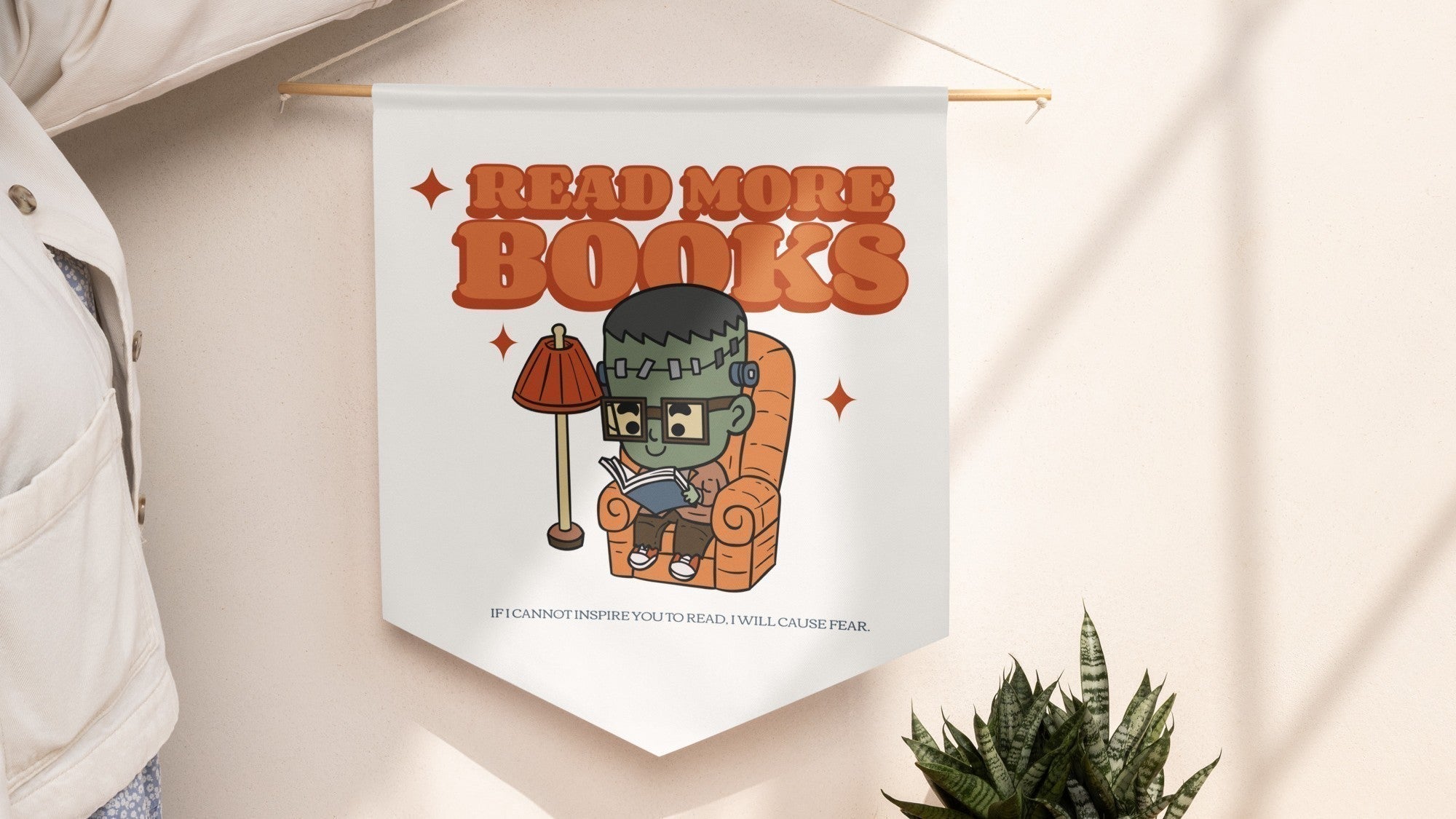 Bookish wall banner featuring a cute cartoon Frankenstein reading, with 'Read More Books' text.