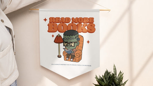 Bookish wall banner featuring a cute cartoon Frankenstein reading, with 'Read More Books' text.