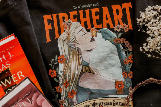 Bookish t-shirt with elf woman, floral design, and 'Fireheart' text, surrounded by fantasy books and flowers