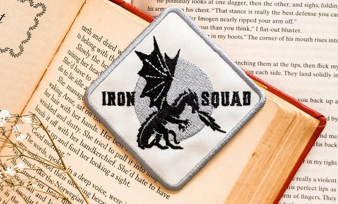 Iron Squad dragon patch on open book, bookish merchandise, fantasy reader gift
