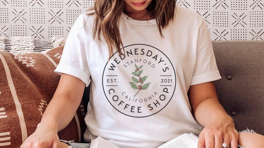 White t-shirt with Wednesday's Stanford Coffee Shop logo, featuring coffee plant design and text.