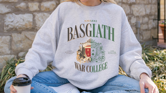 Person wearing a grey Basgiath War College sweatshirt with fantasy crest and green lettering