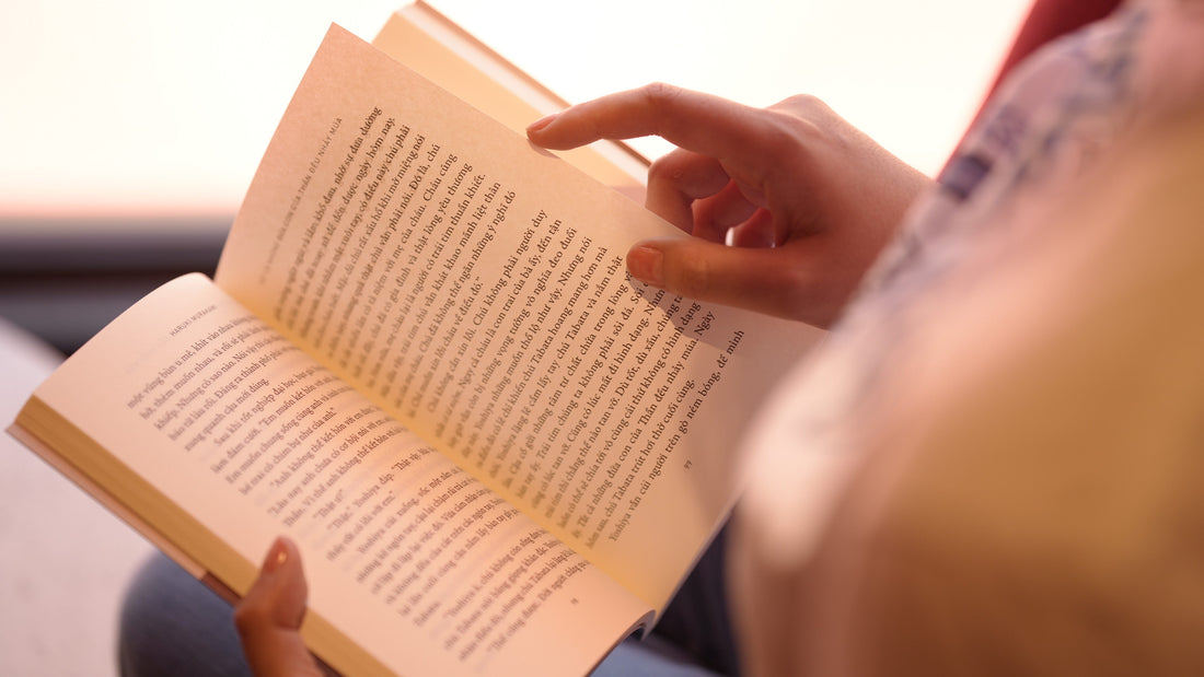 Person reading an open book, close-up of hands and pages, cozy book lover scene