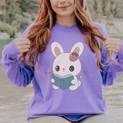 Purple long sleeve tee with cute bunny reading a book graphic, outdoors setting