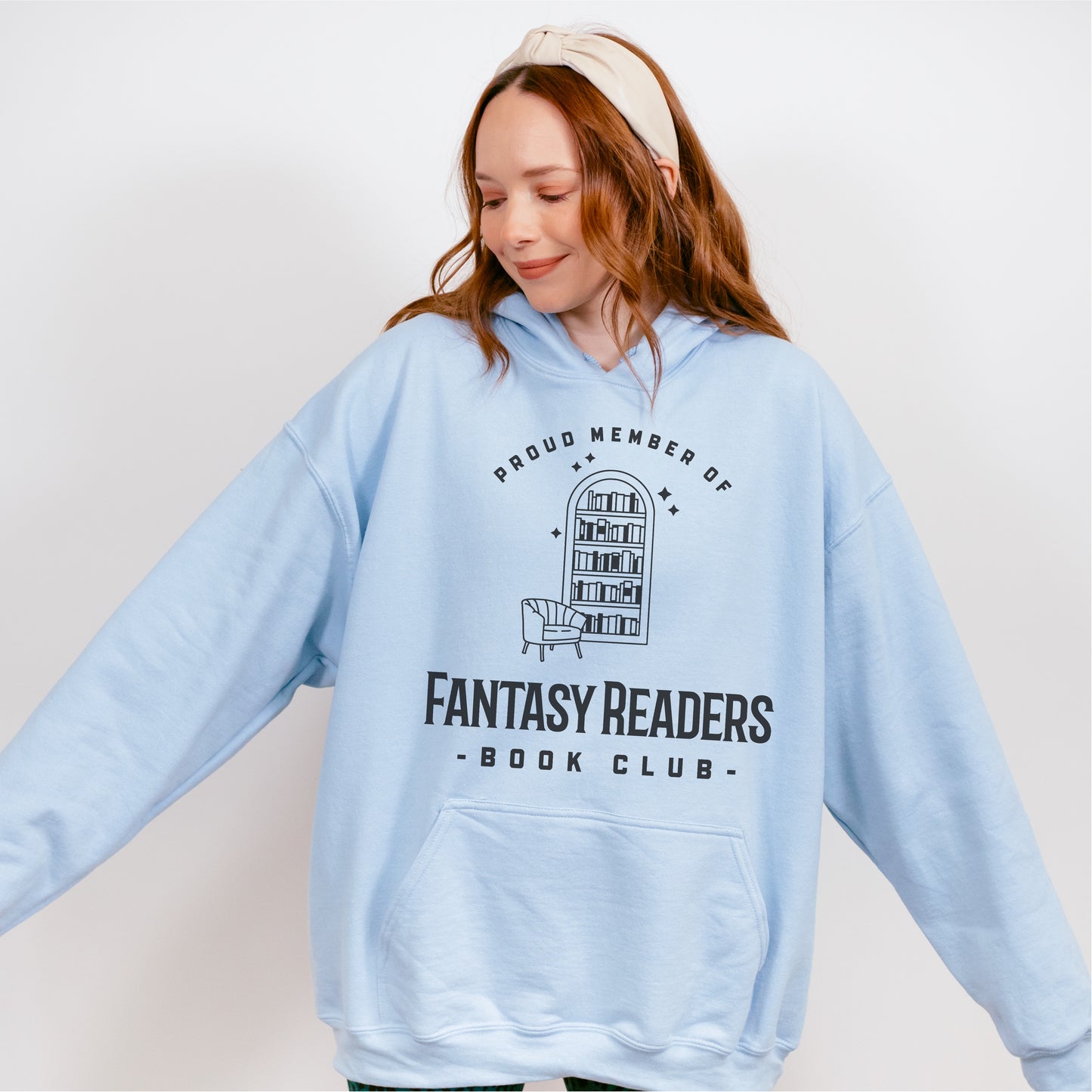 Woman wearing light blue hoodie with 'Fantasy Readers Book Club' and bookshelf graphic.