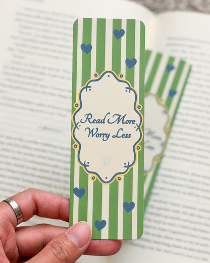 Hand holding a green striped bookmark with text on a book page