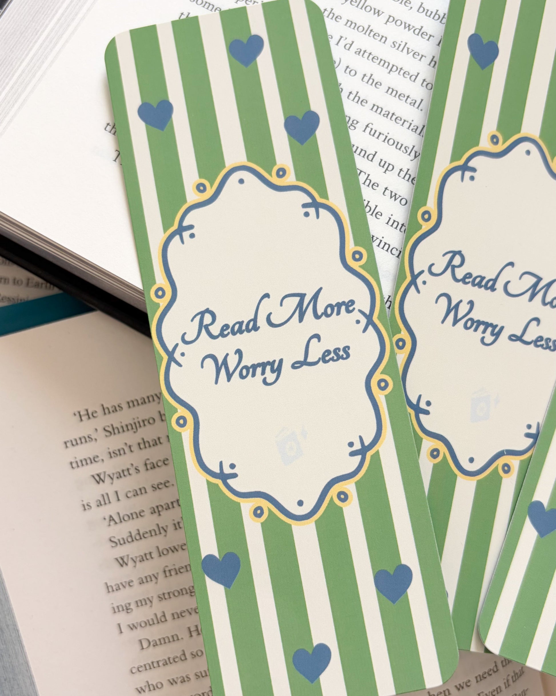 Green striped bookmarks with 'Read More Worry Less' text on a book page.