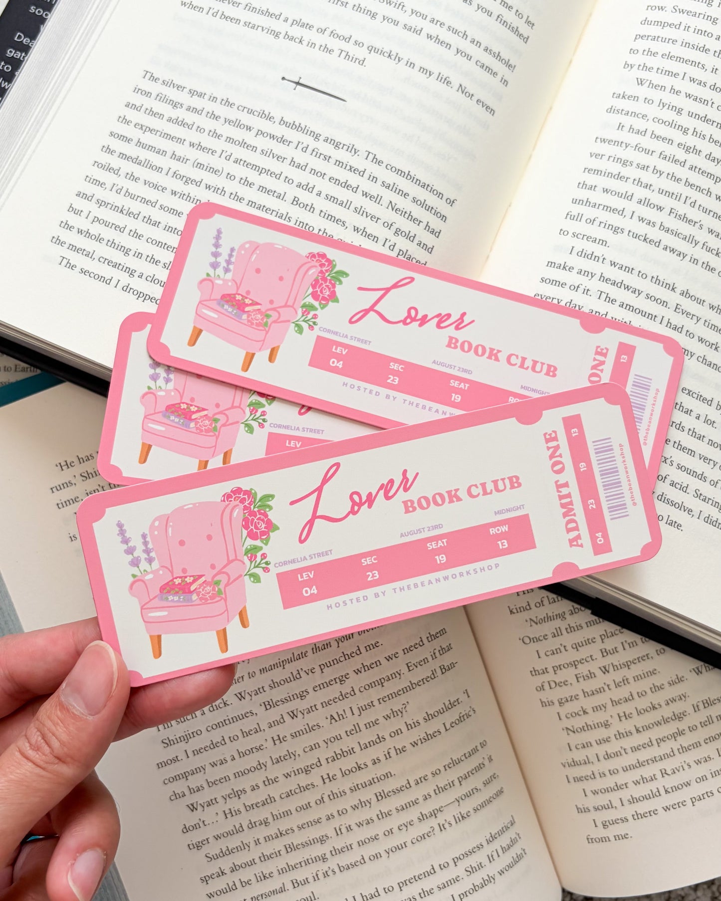 Pink book club bookmarks held over an open book
