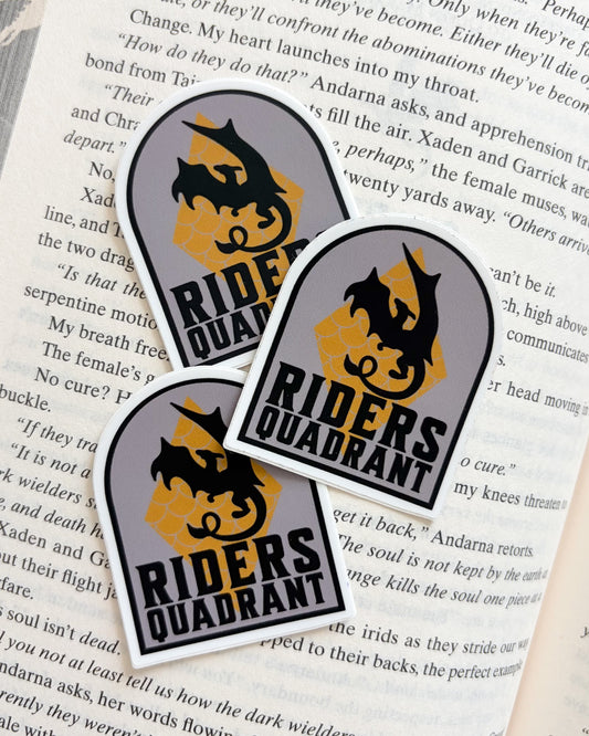 Three 'Riders Quadrant' stickers on a book page