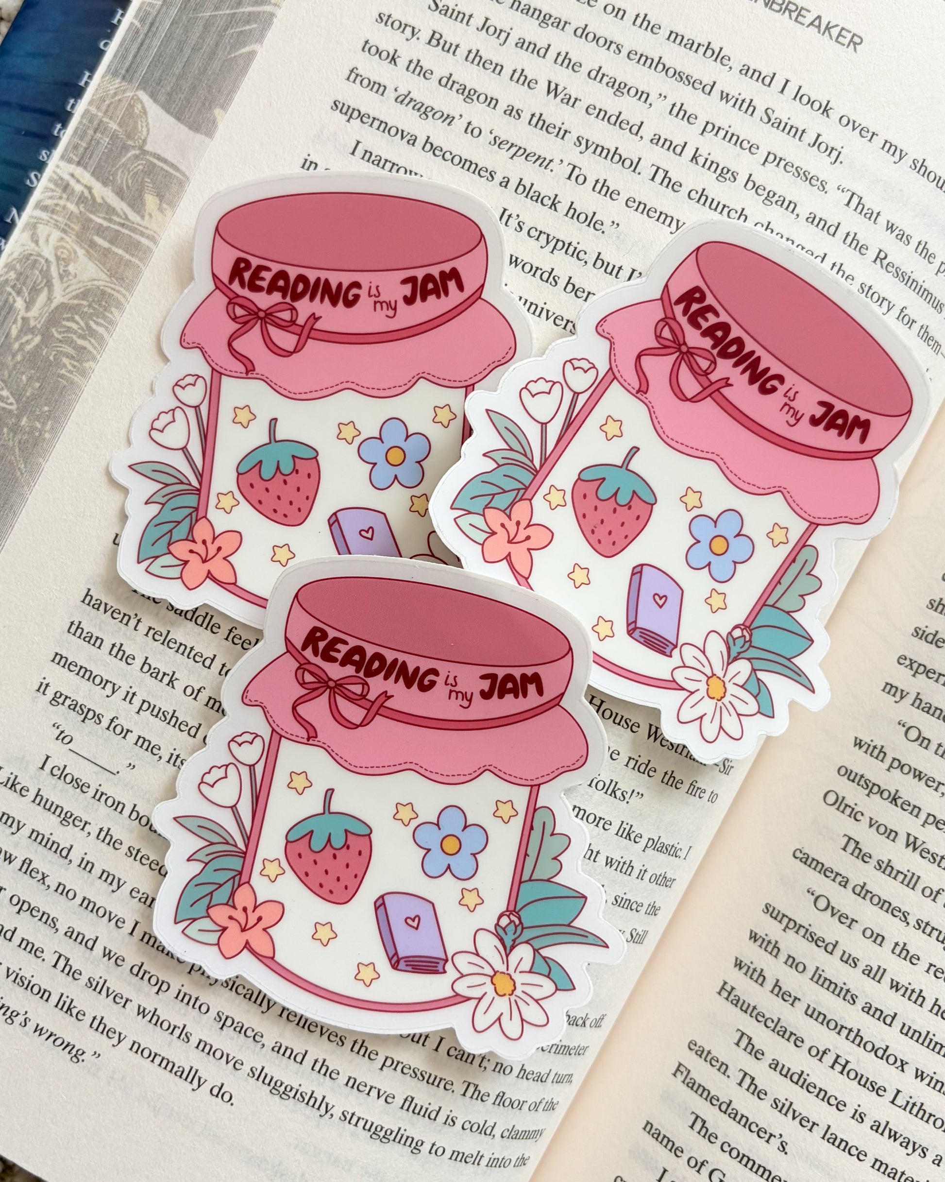 Sticker of a jar labeled 'Reading is my Jam' on an open book