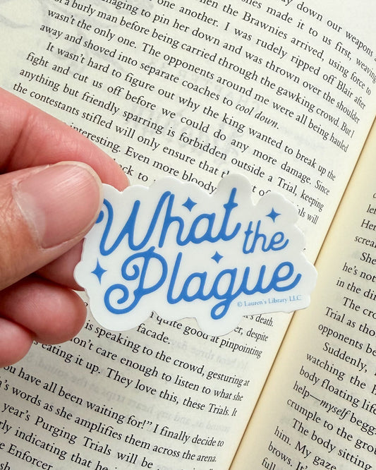 Hand holding a 'What the Plague' sticker over an open book