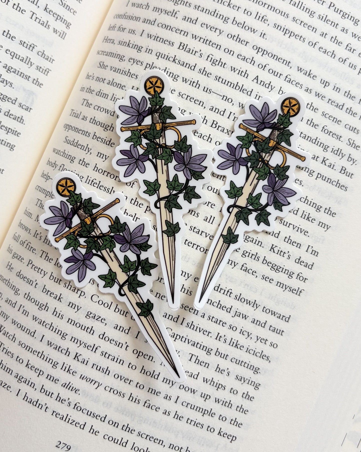 Three decorative brooches with floral designs on an open book