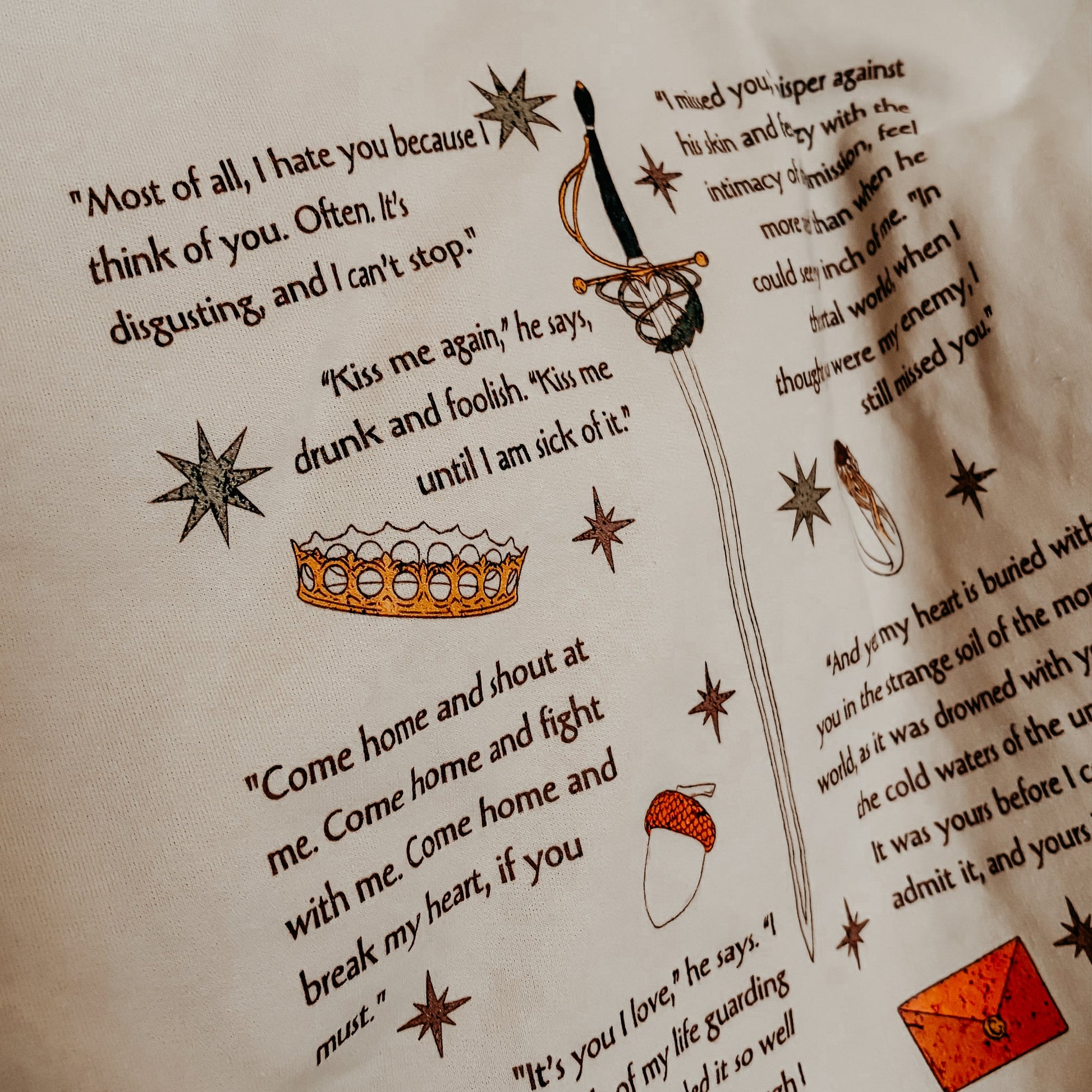 Bookish merchandise with literary quotes, illustrated sword, crown, stars, acorn, and envelope.