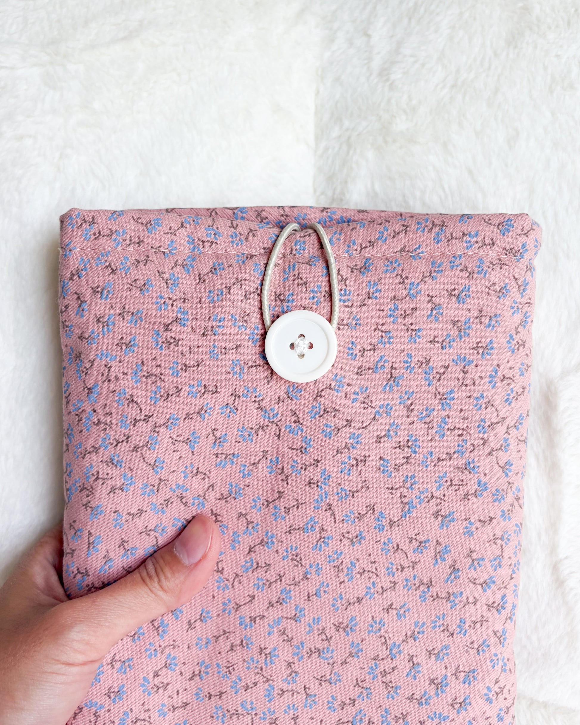 Close-up of pink floral sprig book sleeve button closure detail
