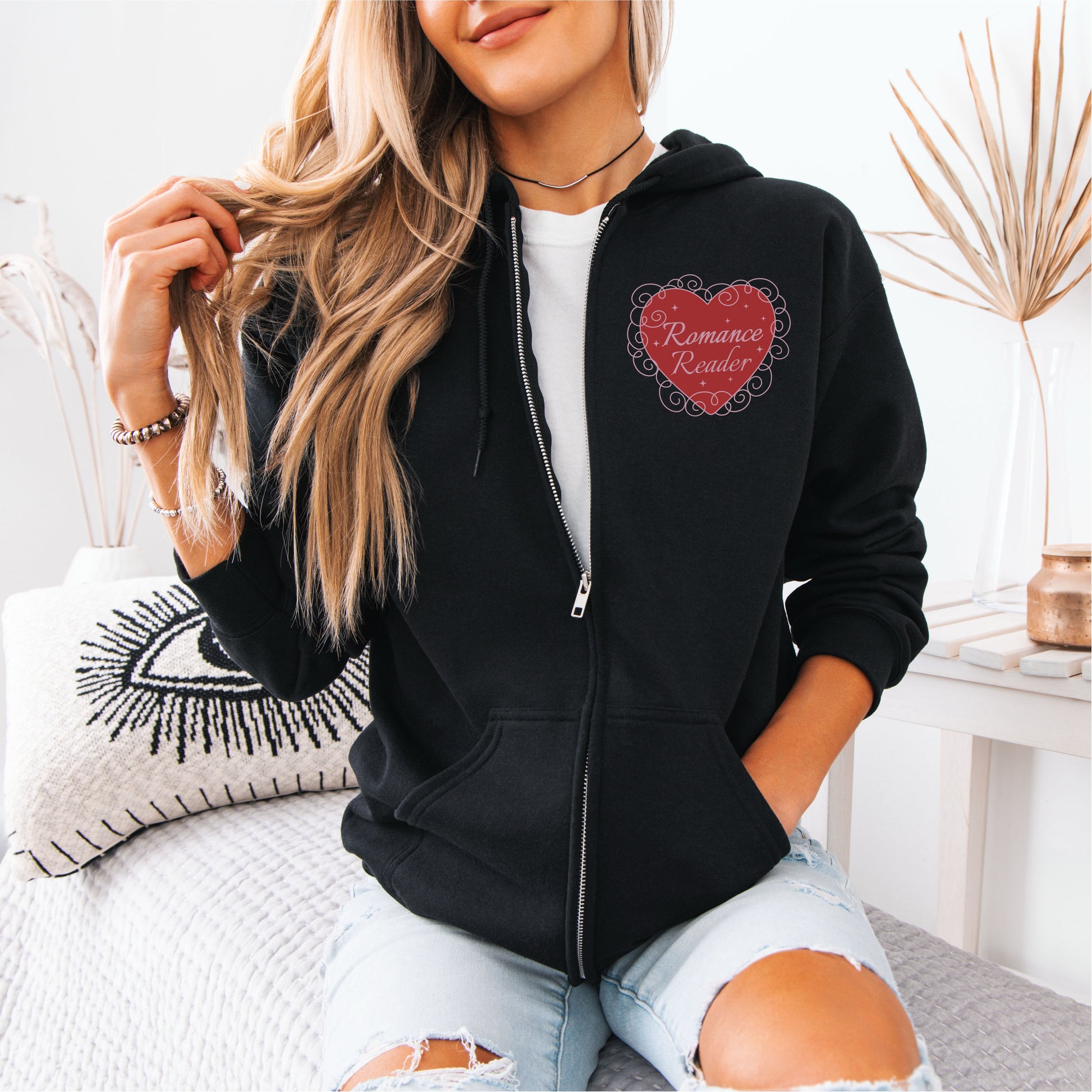 Woman in black zip hoodie with red heart Romance Reader design, casual bookish apparel