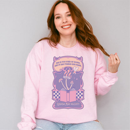 Woman wearing pink "She Is Too Fond of Her Books" Louisa May Alcott sweatshirt with bookish design
