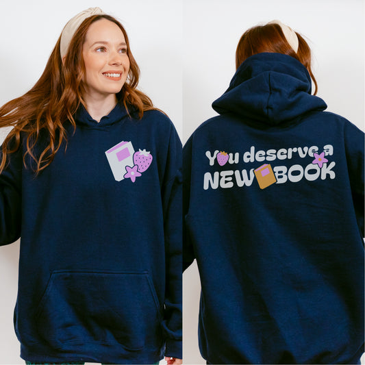 Navy blue book lovers hoodie with strawberry and book graphics, 'You deserve a NEW BOOK' text.