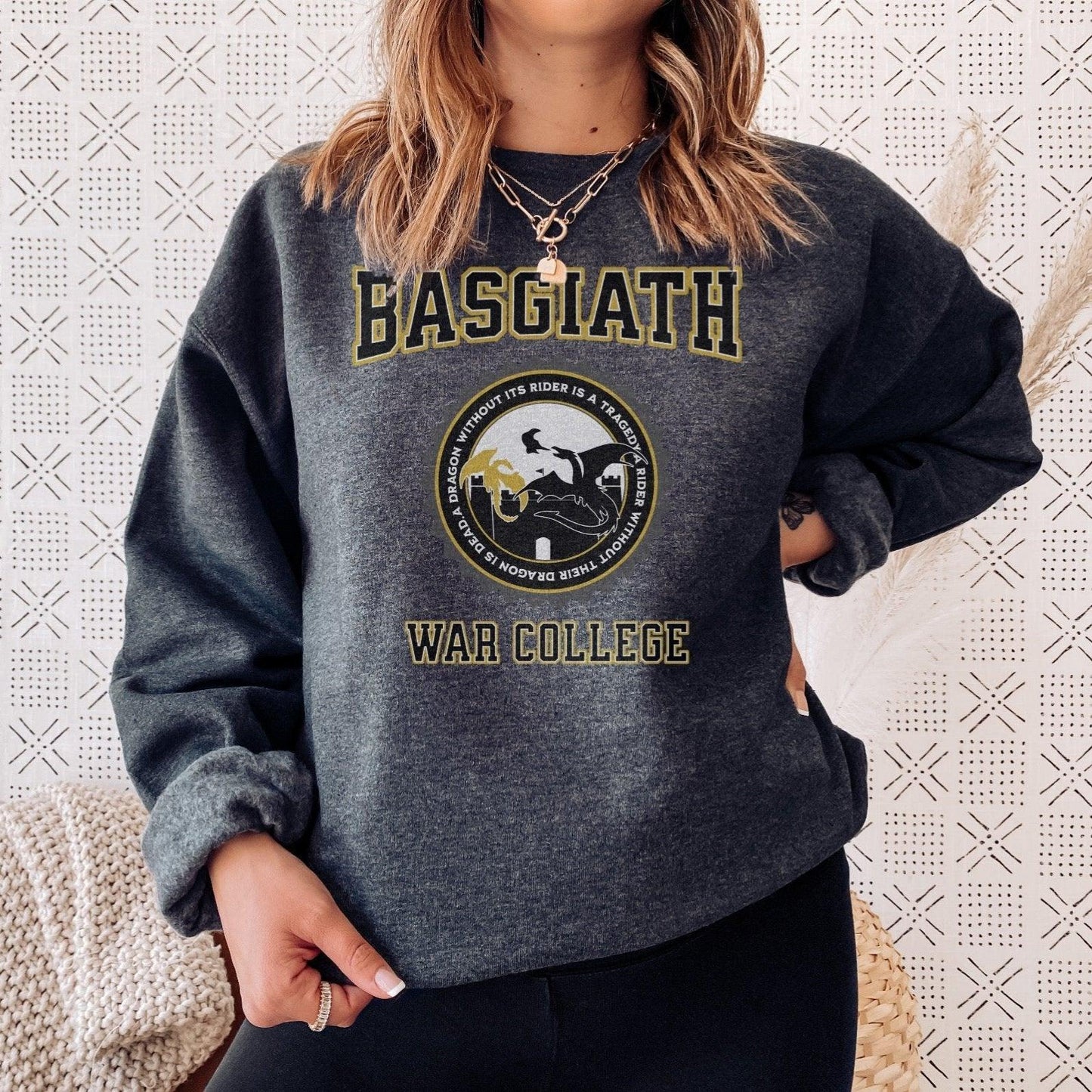 Person wearing a Basgiath War College sweatshirt with dragon and rider graphic