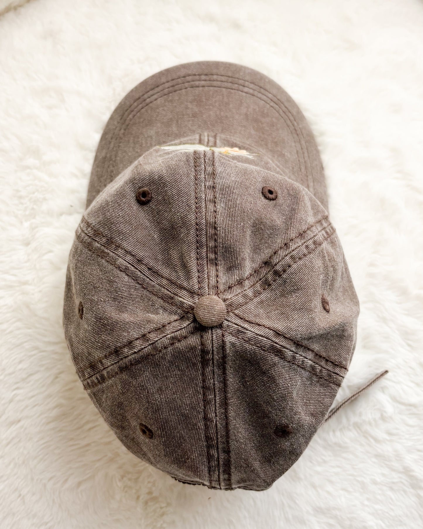 Brown distressed baseball cap on white textured background