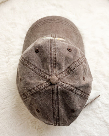 Brown distressed baseball cap on white textured background