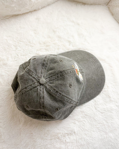 Grey embroidered baseball cap on soft white fabric background