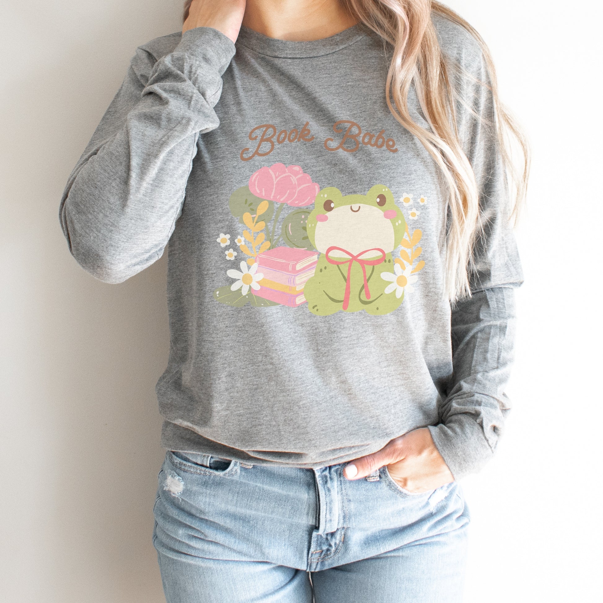 Grey long sleeve tee with 'Book Babe' text, cute frog, books, and floral graphic