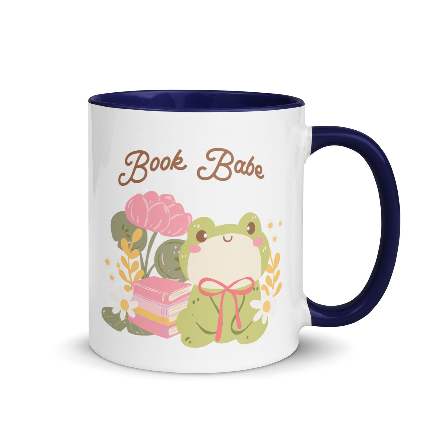 White ceramic mug with dark blue handle, featuring a cute frog, books, flowers, and 'Book Babe' text.