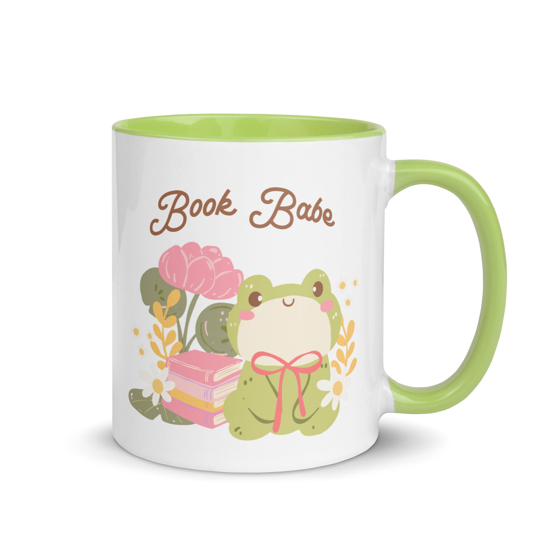 White ceramic mug with green interior, featuring a cute frog, flowers, books, and 'Book Babe' text.