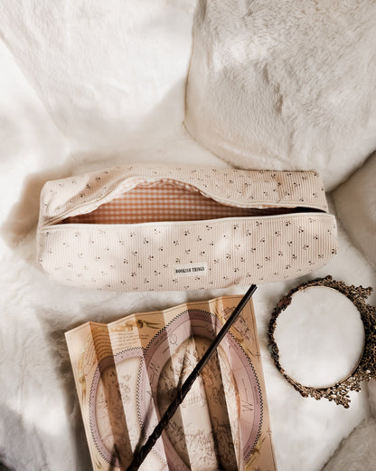 Corduroy hair tool travel bag with floral print, vintage map, wand, and ornate mirror on white fur