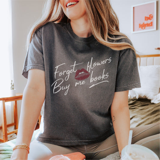 Woman wearing a black tee with 'Forget flowers, Buy me books' lettering and lip graphic