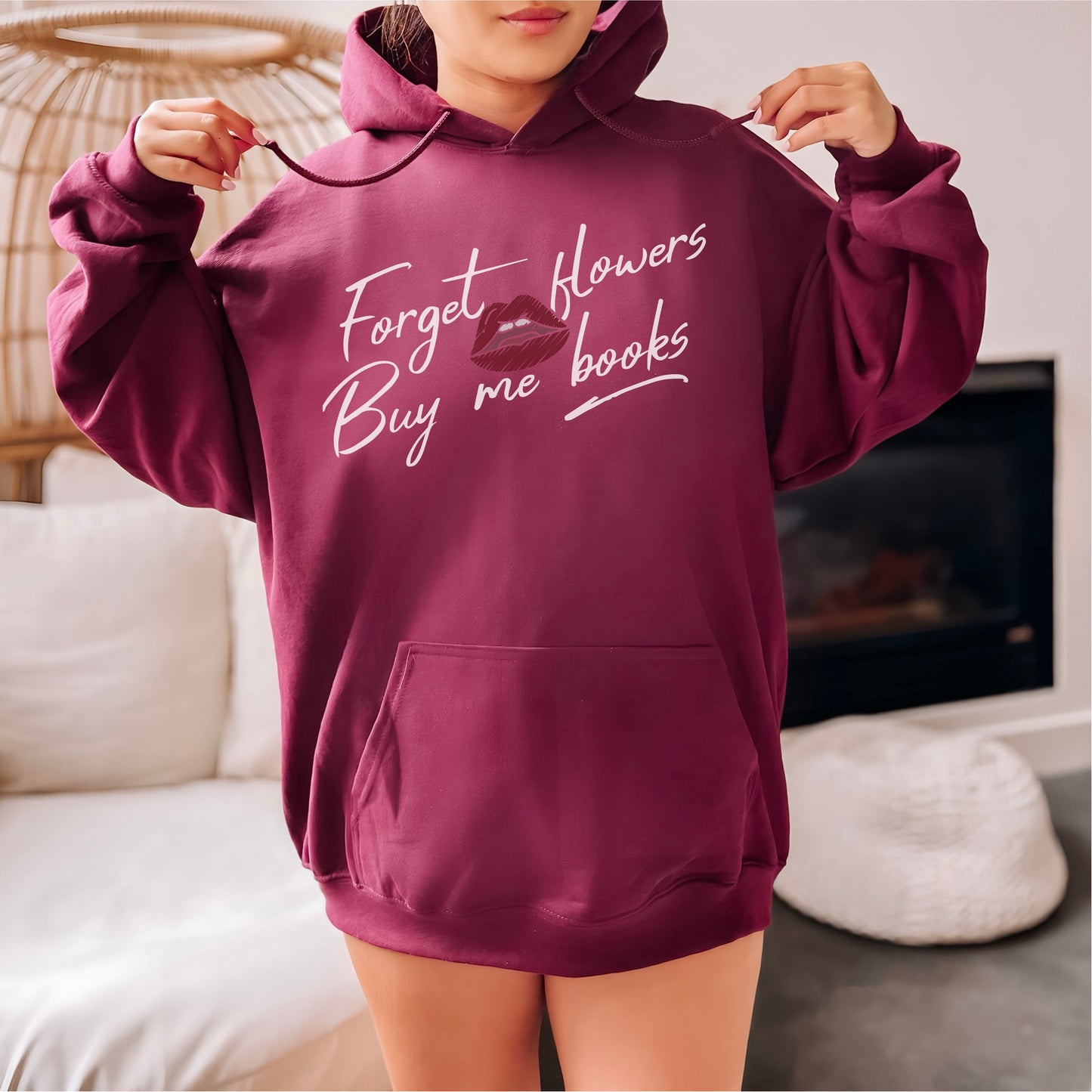 Woman in cozy maroon hoodie with 'Forget flowers buy me books' book lover quote print.