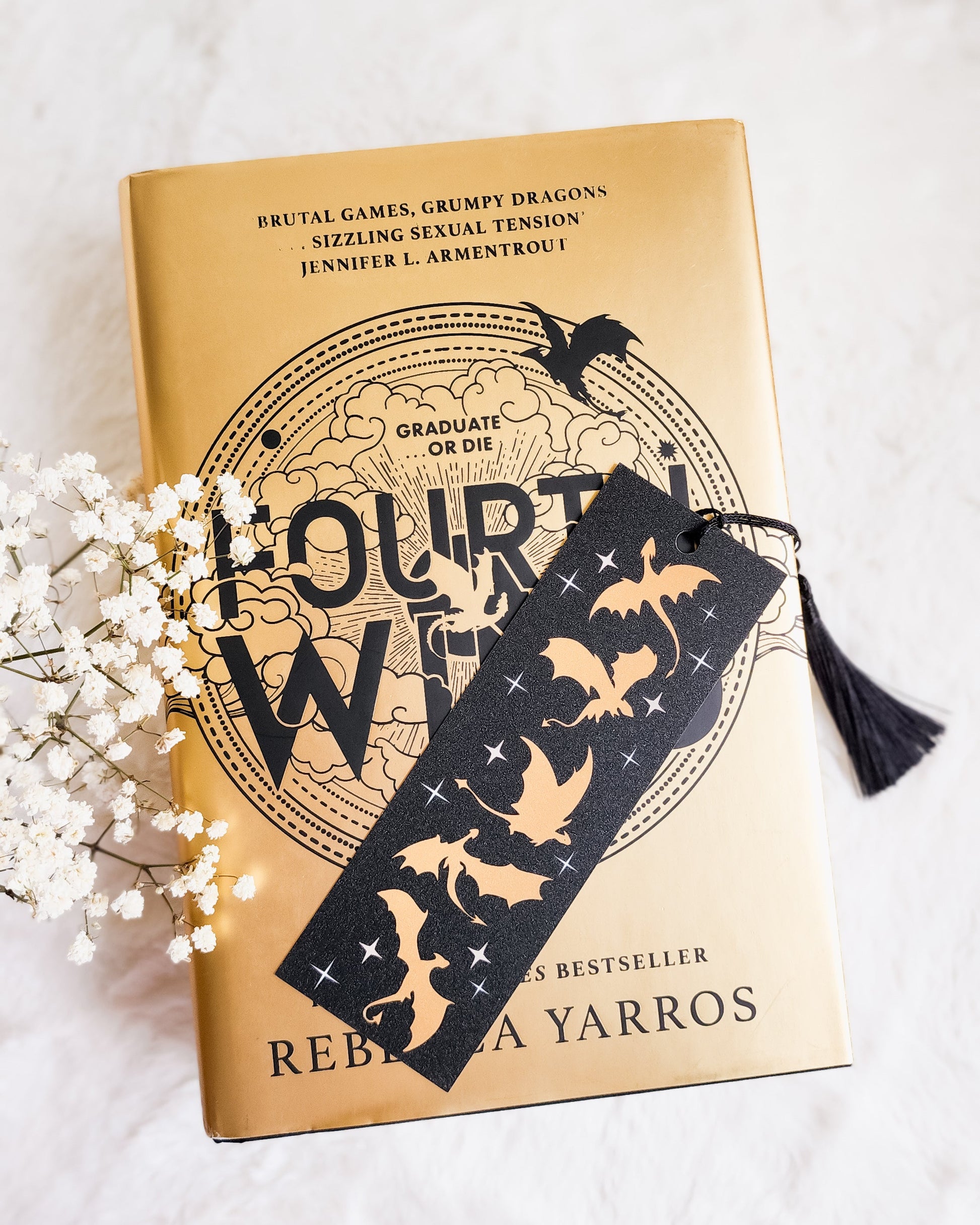 Fourth Wing book by Rebecca Yarros with black dragon-themed bookmark and tassel