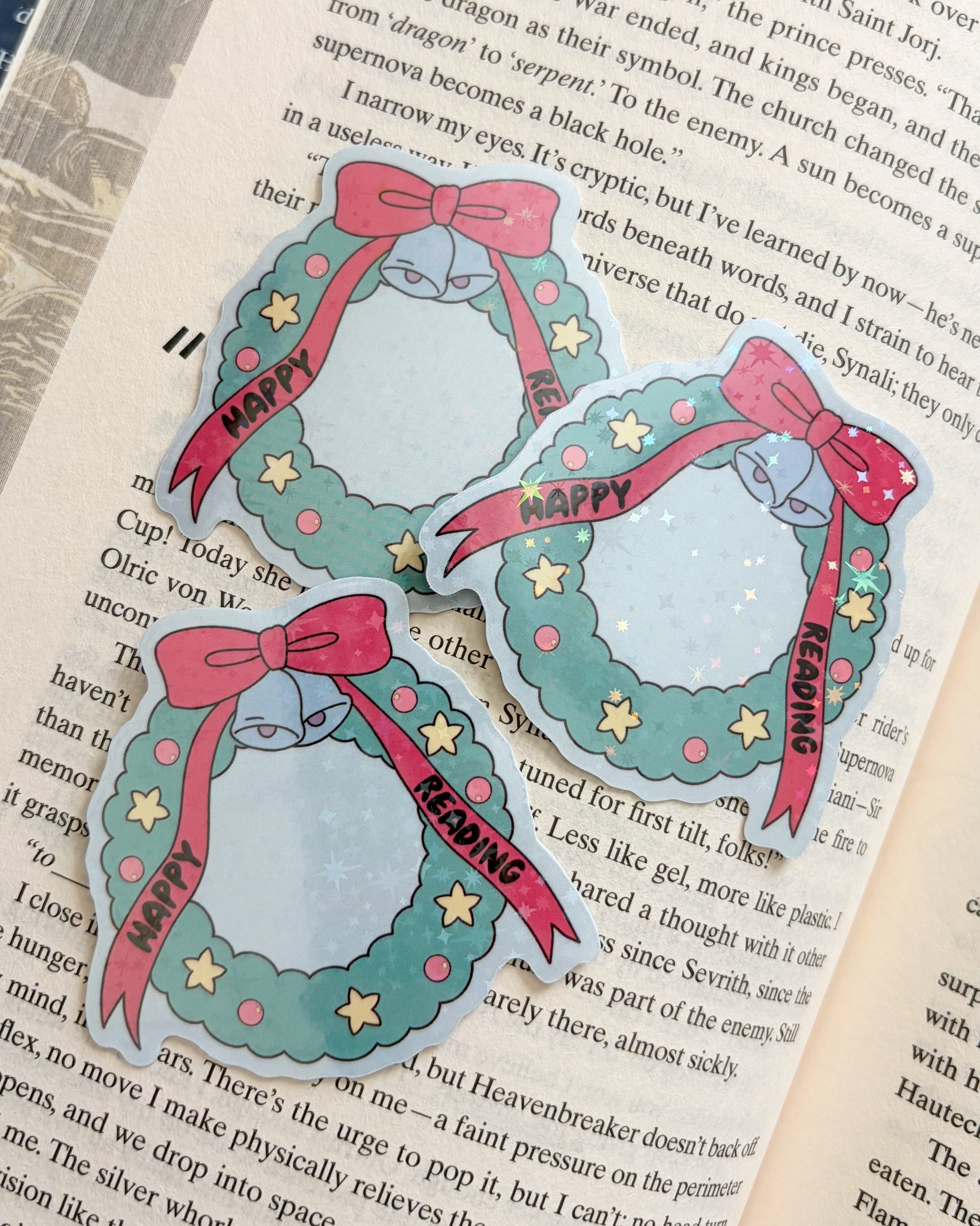 Holographic Christmas wreath stickers with cat, happy reading text, and red bows on book page