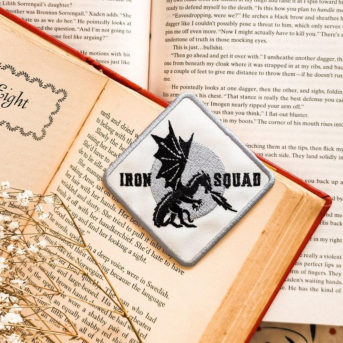 Iron Squad dragon patch on open book, bookish merchandise for readers