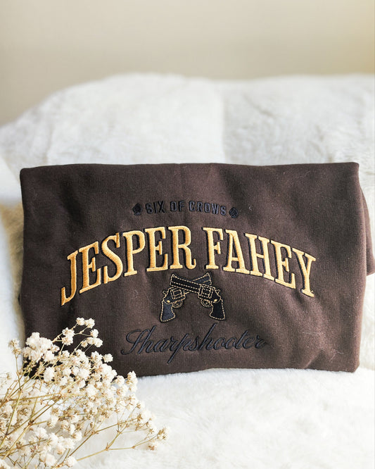 Jesper Fahey Embroidered Sweatshirt - The Bean Workshop - Book Lover Gift, Bookish Sweatshirt, Fantasy Gunslinger, Grishaverse clothing, Jesper Fahey embroidered sweatshirt, Ketterdam, Leigh Bardugo fan apparel for readers, LGBTQ Character, Revolver Embroidery, Six of Crows sharpshooter merch, The Dregs, Wesper, Zemeni