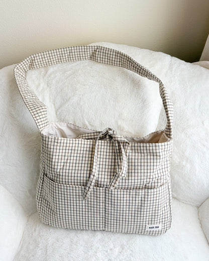 Checkered bag on a white surface with a neutral background