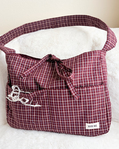Plaid bag with a bow on a white surface
