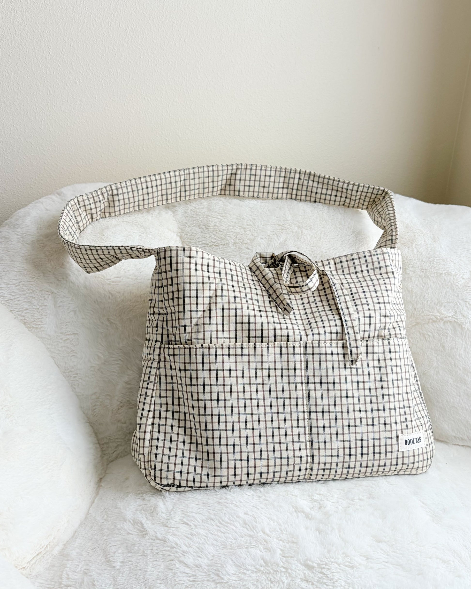 Plaid-patterned bag on a white surface with a neutral background